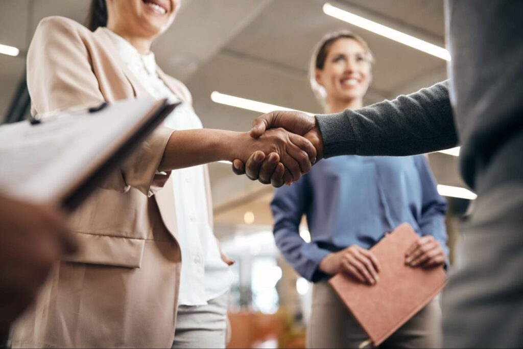 Zwei Geschäftspartner geben sich nach erfolgreichem Vorstellungsgespräch die Hand – Recruiting-Prozess optimieren im Schweizer KMU
